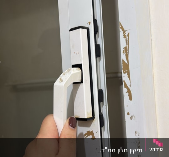 ידית חלון לבנה עם יד אוחזת